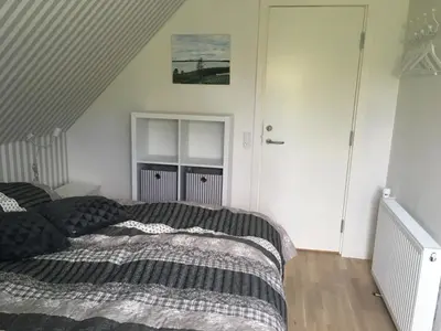 a bedroom with a bed with a black comforter at Nationalpark Thy guesthouse in Vestervig