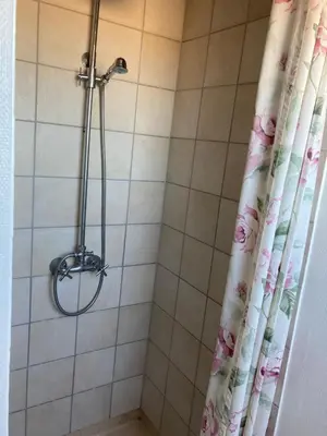 a shower with a shower head and a shower curtain at Kallerup Hgård in Thisted