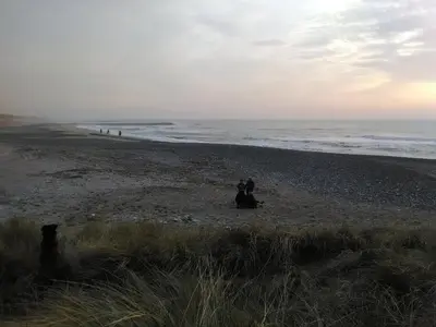 a couple of people sitting on a beach at Rikke og Franks Svineri in Lemvig