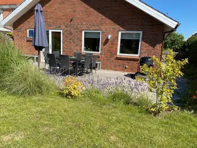 a brick house with a table and an umbrella at Event4U in Nykøbing Mors