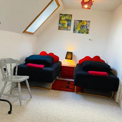 two beds in a room with a table and a lamp at Event4U in Nykøbing Mors