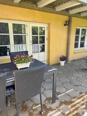 a table and chairs with flowers on a patio at Munkebo B&B, Thy in Thisted