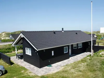 a black house with a car parked in front of it at Luxury Beach House in Blokhus - By Traum Ferienwohnungen in Blokhus