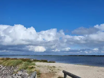a body of water with a bench on a beach at 6 person holiday home in Løgstør in Løgstør