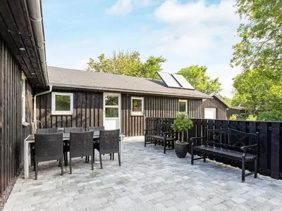 a patio with chairs and a table and a building at 6 person holiday home in Løgstør in Løgstør
