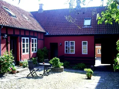 a red house with a table and chairs in front of it at Latinerkvarteret in Viborg