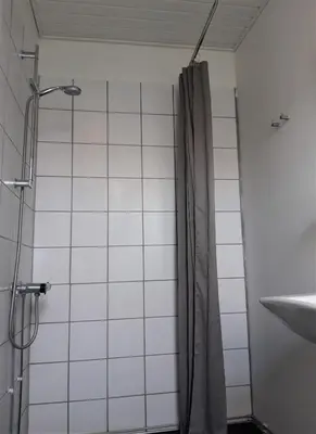a shower with a shower curtain in a bathroom at Latinerkvarteret in Viborg