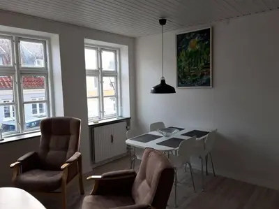 a living room with a dining room table and chairs at Latinerkvarteret in Viborg