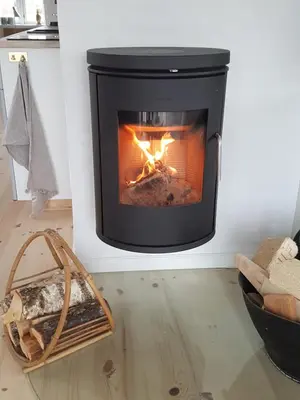 a fire in a fireplace in a living room at Fiskerhuset in Agger