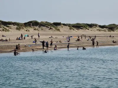 a group of people on a beach with the water at Fiskerhuset in Agger