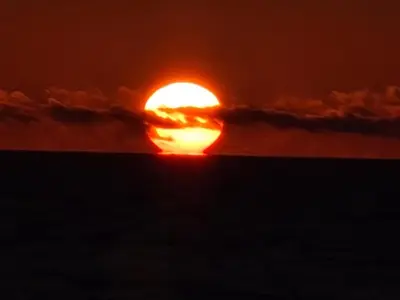 a sun setting in the middle of the ocean at Fiskerhuset in Agger