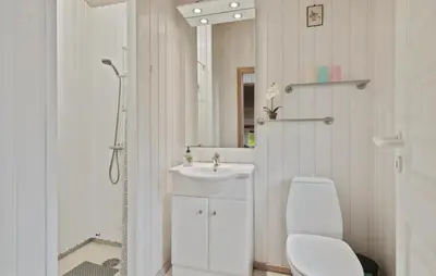 a white bathroom with a toilet and a sink at Holiday Home Odavej Løkken Xi in Løkken