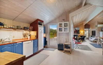 a kitchen with blue cabinets and a dining room at Holiday Home Odavej Løkken Xi in Løkken