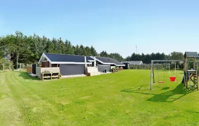 a large yard with a house and a playground at Holiday Home Odavej Løkken Xi in Løkken