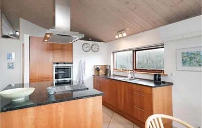 a kitchen with wooden cabinets and a counter top at Holiday Home Ruthsvej in Løkken