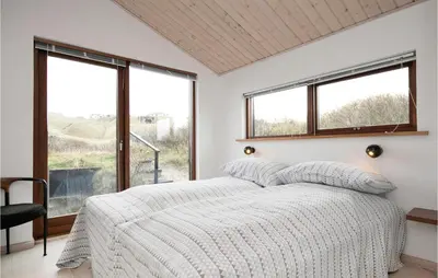 a bedroom with a bed and a large window at Holiday Home Ruthsvej in Løkken