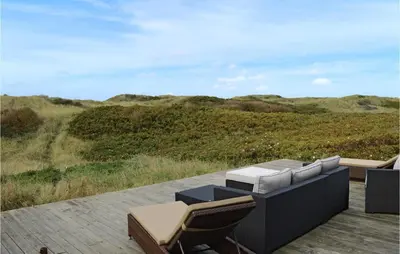 a patio with chairs and a table on a deck at Holiday Home Ruthsvej in Løkken