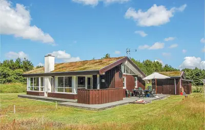 a small house with a deck and a patio at Holiday Home Sarasvej Løkken in Løkken