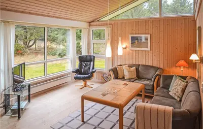 a living room with a couch and a table at Holiday Home Sarasvej Løkken in Løkken
