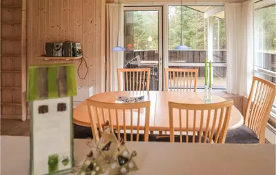a kitchen and dining room with a table and chairs at Holiday Home Sarasvej Løkken in Løkken
