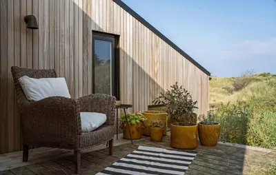 a patio with chairs and potted plants on a deck at Nice Home In Saltum With Kitchen in Saltum