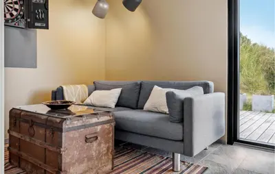 a living room with a gray couch and a wooden trunk at Nice Home In Saltum With Kitchen in Saltum
