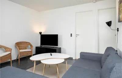 a living room with a couch and a table at Nice Home In Blokhus With Sauna in Blokhus