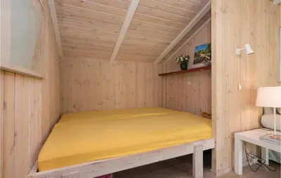 a room with a bed in a wooden house at Holiday Home Moreavej in Blokhus