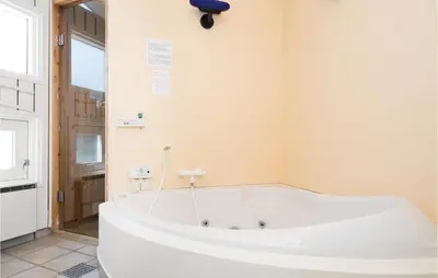 a large white bath tub in a bathroom at Holiday Home Moreavej in Blokhus