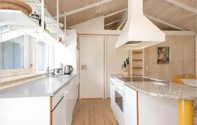a kitchen with white cabinets and a counter top at Holiday Home Moreavej in Blokhus