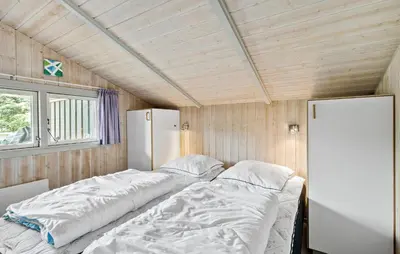 a bed in a small room with a refrigerator at Holiday Home Østersvej Fjerritslev Xii in Fjerritslev