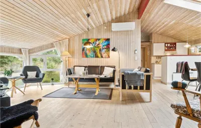 a living room with a table and chairs at Holiday Home Harestien Brovst in Brovst