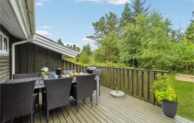 a patio with a table and chairs on a deck at Holiday Home Harestien Brovst in Brovst