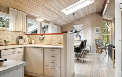 a kitchen with a table and a dining room at Holiday Home Harestien Brovst in Brovst