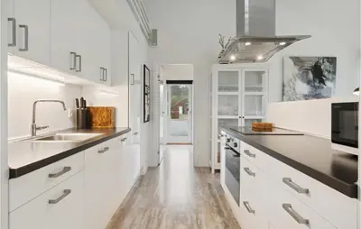 a kitchen with white cabinets and a sink at Holiday Home Kronvildtvej Brovst Ii in Brovst
