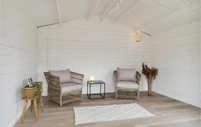 a room with two chairs and a table with a candle at Holiday Home Kronvildtvej Brovst Ii in Brovst