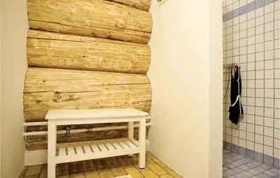 a bathroom with a bench next to a wooden wall at 9 Bedroom Beautiful Home In Lemvig in Lemvig