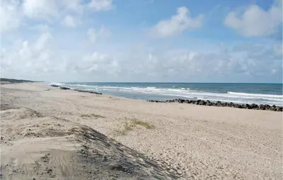 a beach with a bunch of rocks and the ocean at Holiday Home Kjeldbjergvej Lemvig Iii in Lemvig