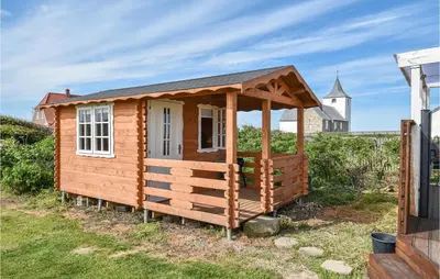 a wooden cabin with a roof on the grass at Holiday Home Kjeldbjergvej Lemvig Iii in Lemvig