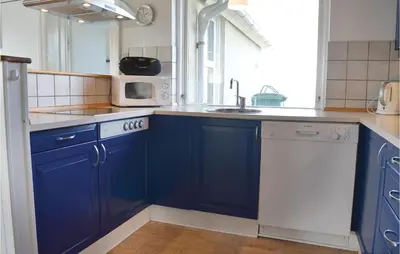 a blue kitchen with a sink and a microwave at Holiday Home Kjeldbjergvej Lemvig Iii in Lemvig