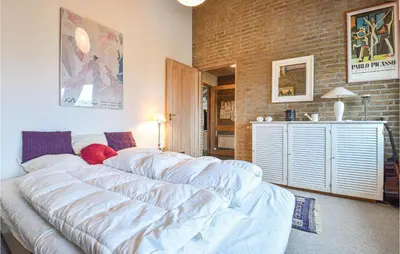a living room with a large bed and a brick wall at Klitborgen in Harboør