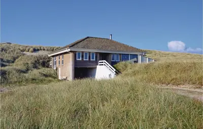 a house sitting on top of a grass covered hill at Klitborgen in Harboør