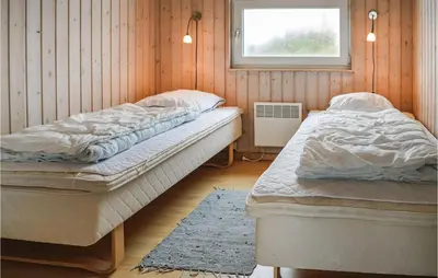 two twin beds in a room with a window at Holiday Home Themisvej Harboøre Xii in Harboør