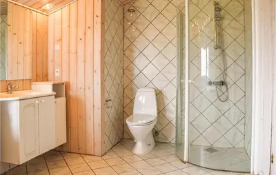 a bathroom with a toilet and a glass shower at Holiday Home Themisvej Harboøre Xii in Harboør