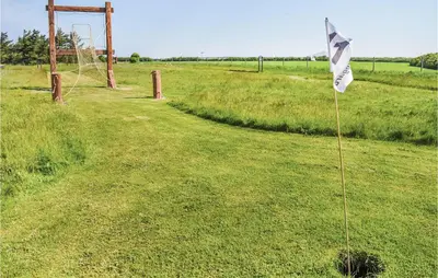 a flag in the middle of a field at Holiday Home Themisvej Harboøre Xii in Harboør