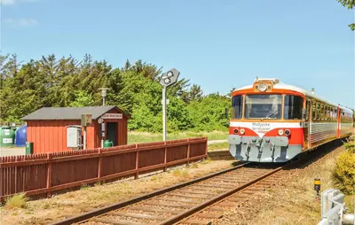 an orange train is coming down the tracks at Holiday Home Themisvej Harboøre Xii in Harboør