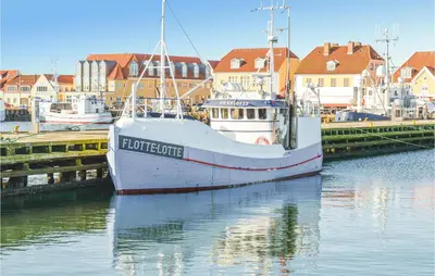 a boat docked at a dock in a harbor at Holiday Home Vejlby Klit in Harboør