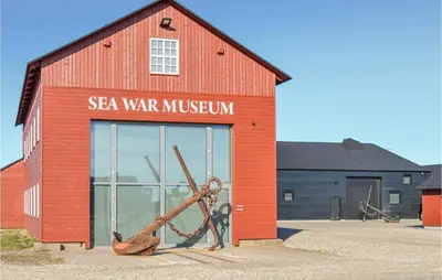 a red building with asea war museum with a sculpture in front at Holiday Home Vejlby Klit in Harboør