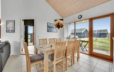 a dining room and living room with a table and chairs at Holiday Home Klitengene Ulfborg Vi in Ulfborg