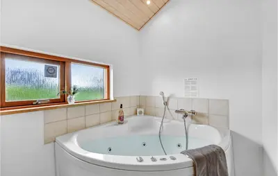 a white bath tub in a bathroom with a window at Holiday Home Klitengene Ulfborg Vi in Ulfborg